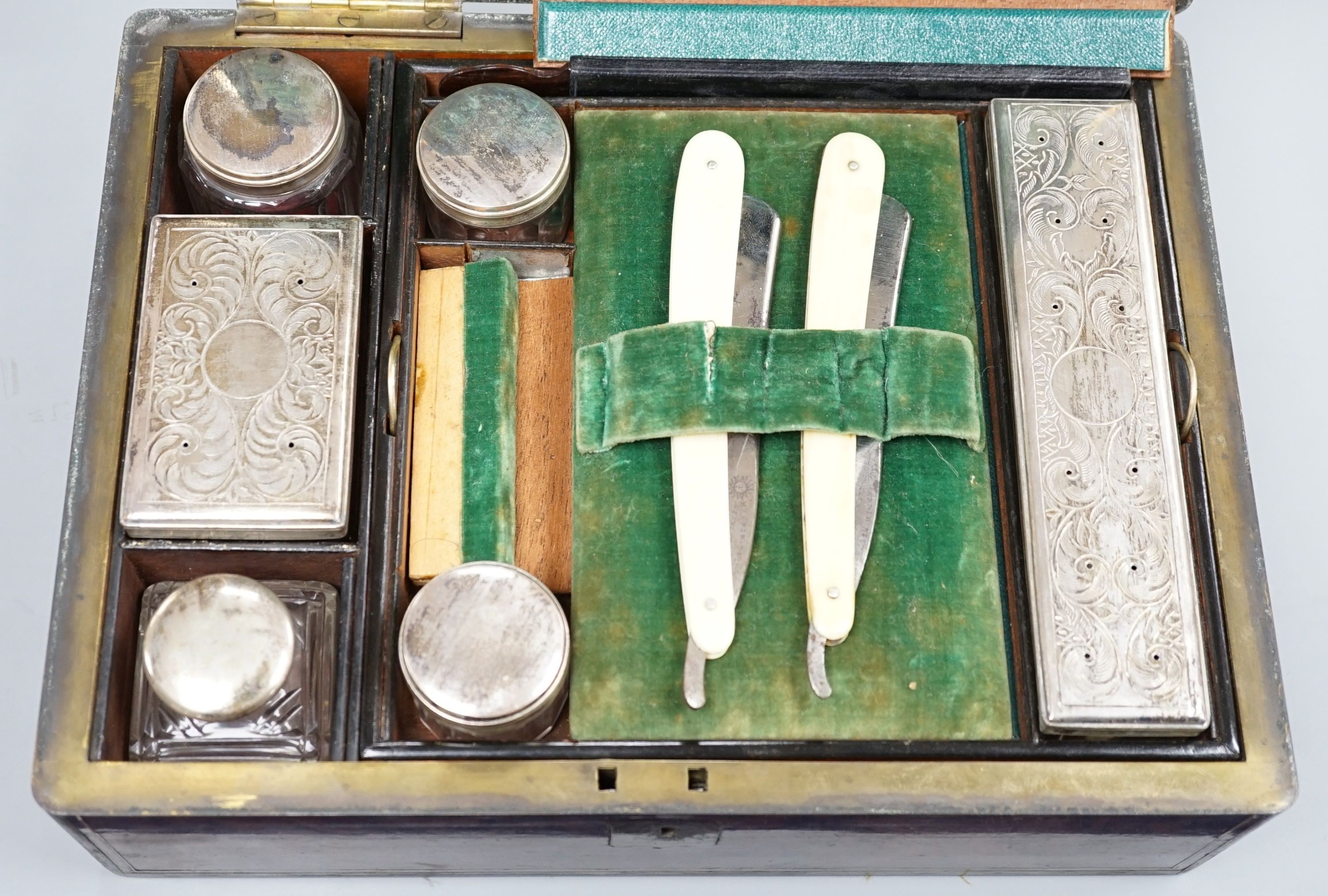 A Victorian brass mounted burr walnut toilet box, fitted with glass jars with electroplated tops, Width 30 cms. Ivory mounted items included